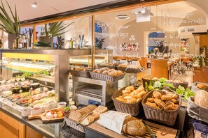A bakery display with various breads, pastries, and cheeses. - Best Western Hotel Moran (Prague)