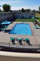 Una piscina al aire libre de temporada, sombrillas