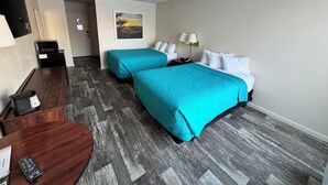 A hotel room with two beds, a desk, a chair, a TV, and a painting on the wall. - Hot Springs Hotel and Spa (Thermopolis)