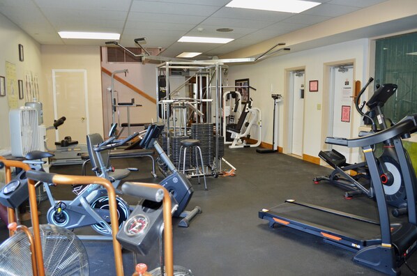 A gym with treadmills, elliptical machines, and weightlifting equipment.