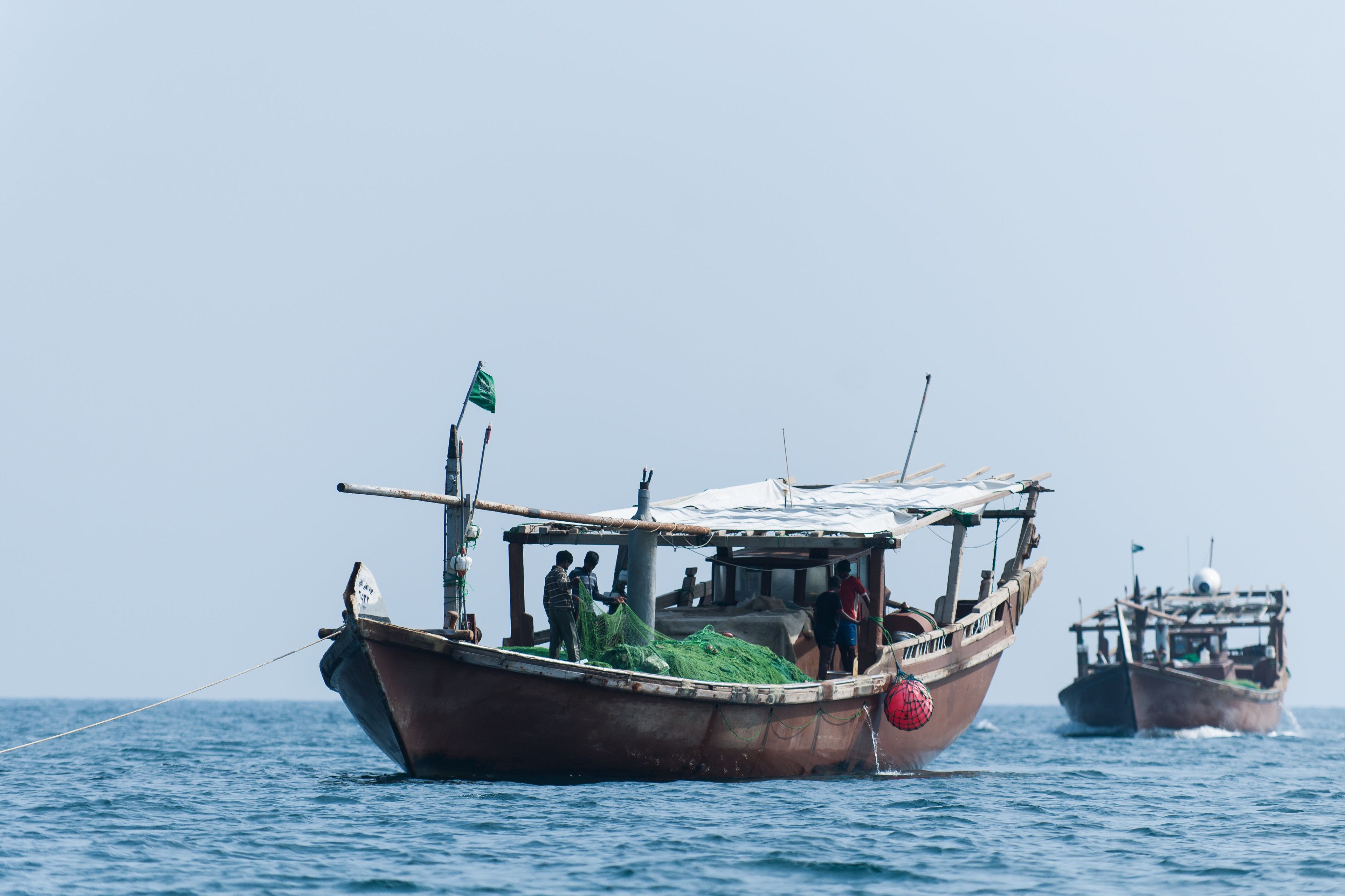 A boat with people on deck and another boat in the background.