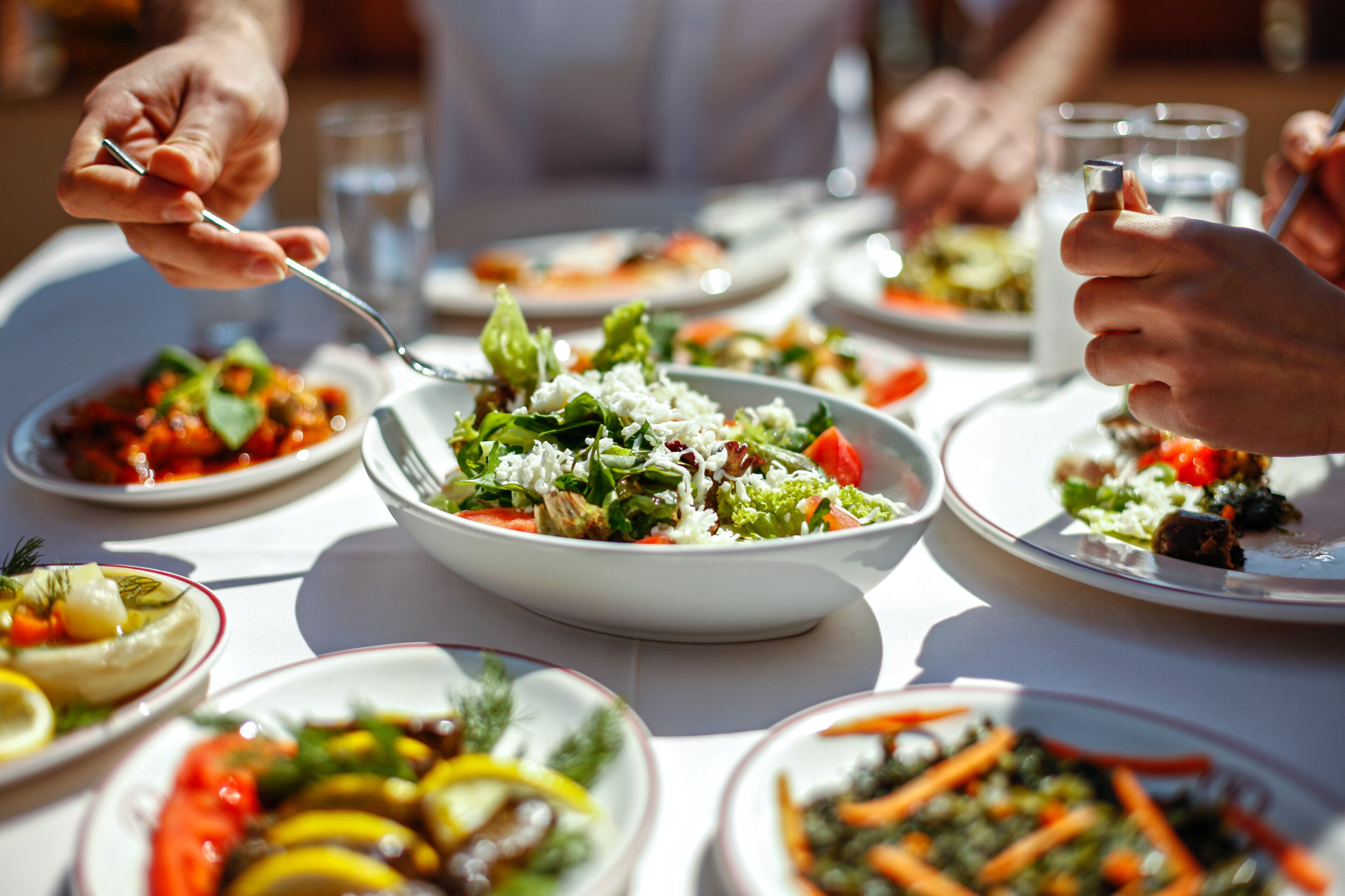 Una mesa de comedor con diversos platos, incluyendo ensaladas y verduras.