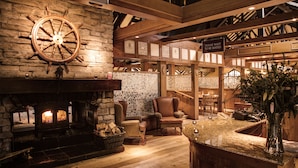 A cozy interior with a stone fireplace, wooden beams, and a sign indicating a wait area. - Culloden Estate & Spa (Holywood)