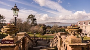A stone staircase leading to a building with a view of a body of water and a distant landscape. - Culloden Estate & Spa (Holywood)