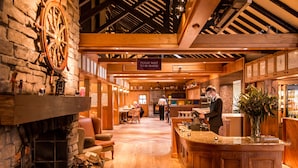 A cozy, rustic interior with a stone fireplace, wooden beams, and a bar area. - Culloden Estate & Spa (Holywood)