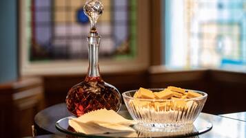 A clear glass decanter and a bowl of butter on a reflective surface.