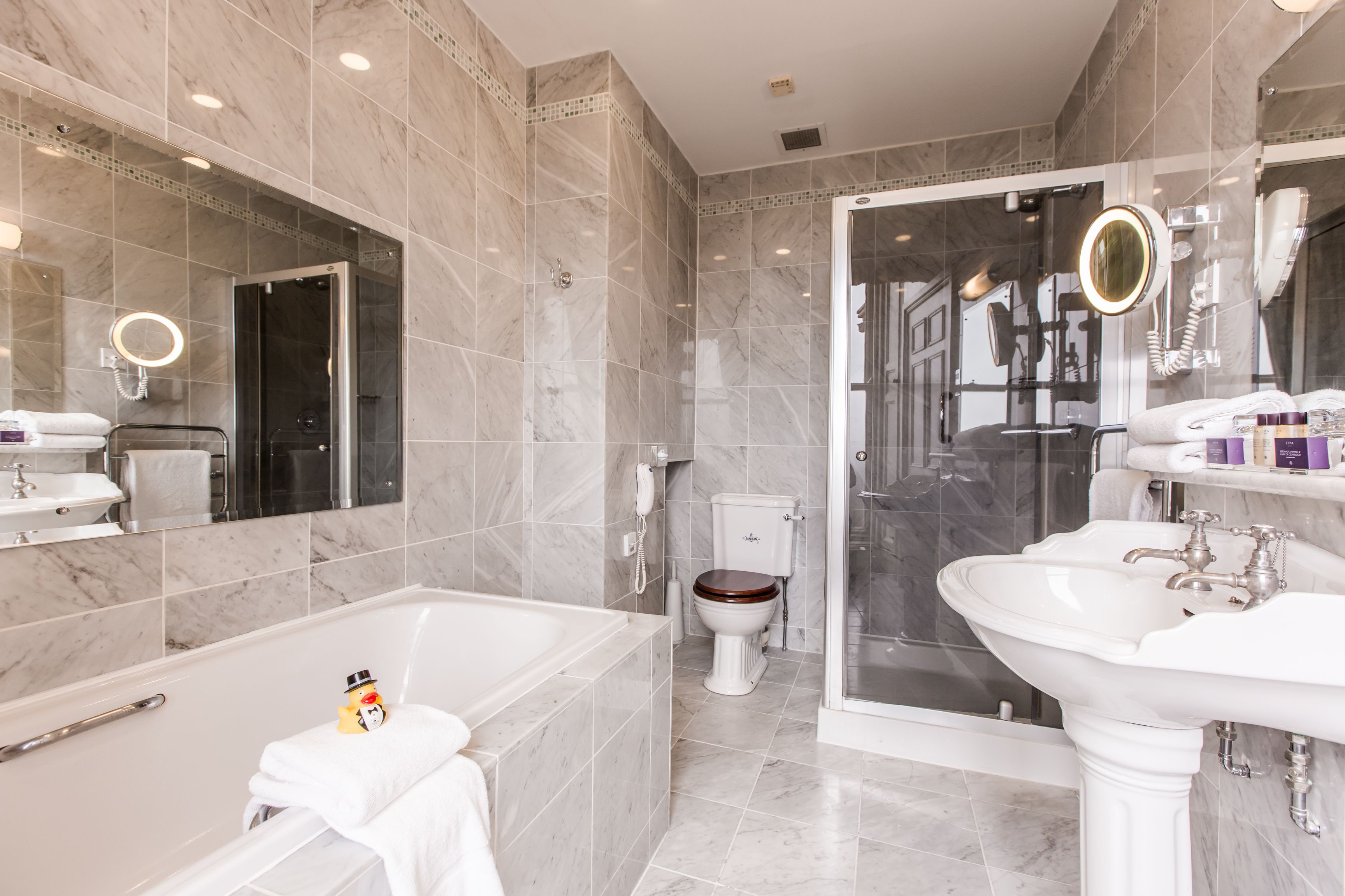 Ein modernes Badezimmer mit einer Badewanne, einer Toilette, einer Duschkabine und einem Waschbecken.