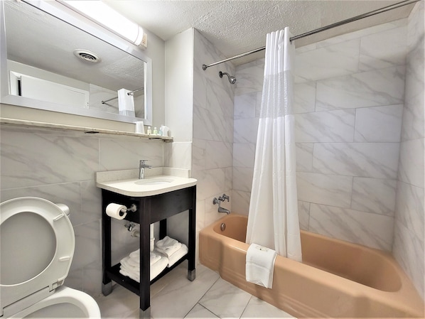 A bathroom with a toilet, sink, and bathtub.