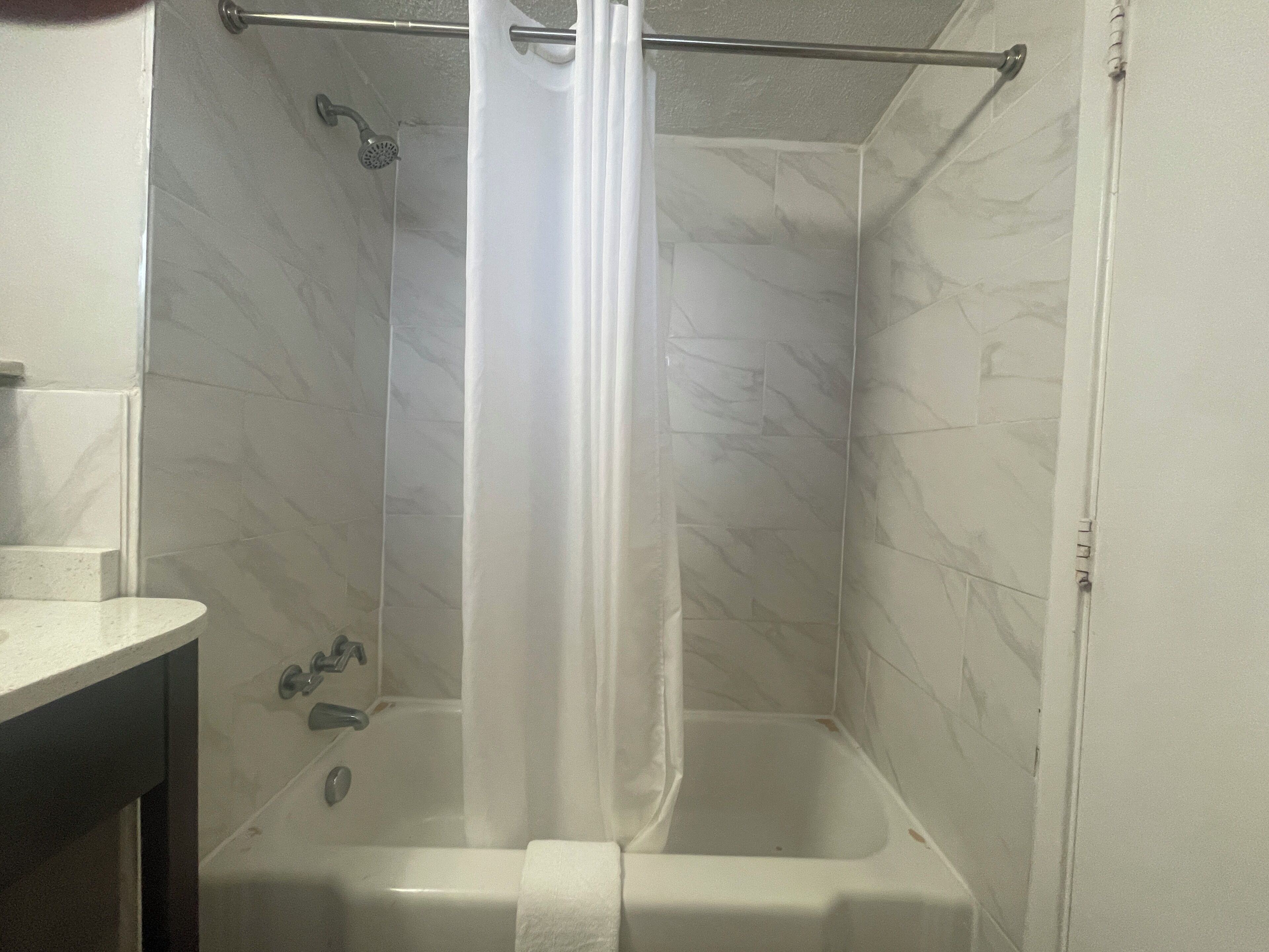 A bathroom with a shower, a bathtub, and a toilet.