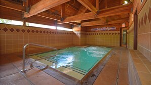 A wooden interior with a pool area, tiled walls, and a metal pool ladder. - Quality Inn Near Mammoth Mountain Ski Resort (Mammoth Lakes)