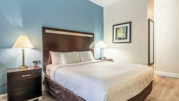 A neatly made bed with white linens, a dark headboard, and two bedside lamps.