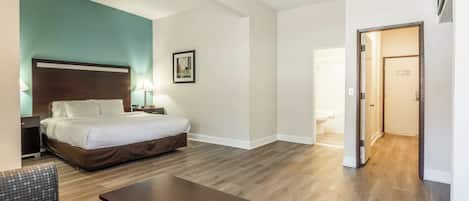 Habitación de hotel con cama, mesita de noche, lámpara y un cuadro en la pared.