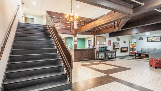A spacious lobby with a staircase, a fireplace, and a seating area. - Quality Inn Near Mammoth Mountain Ski Resort (Mammoth Lakes)