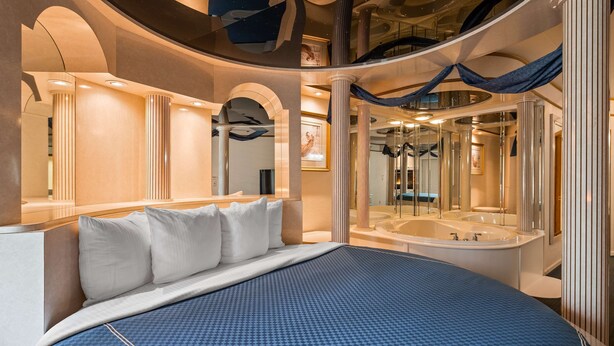 A luxurious bedroom with a large bed, a separate bathroom with a bathtub, and a view of the hotel's interior. - Best Western Galena Inn & Suites (Galena)