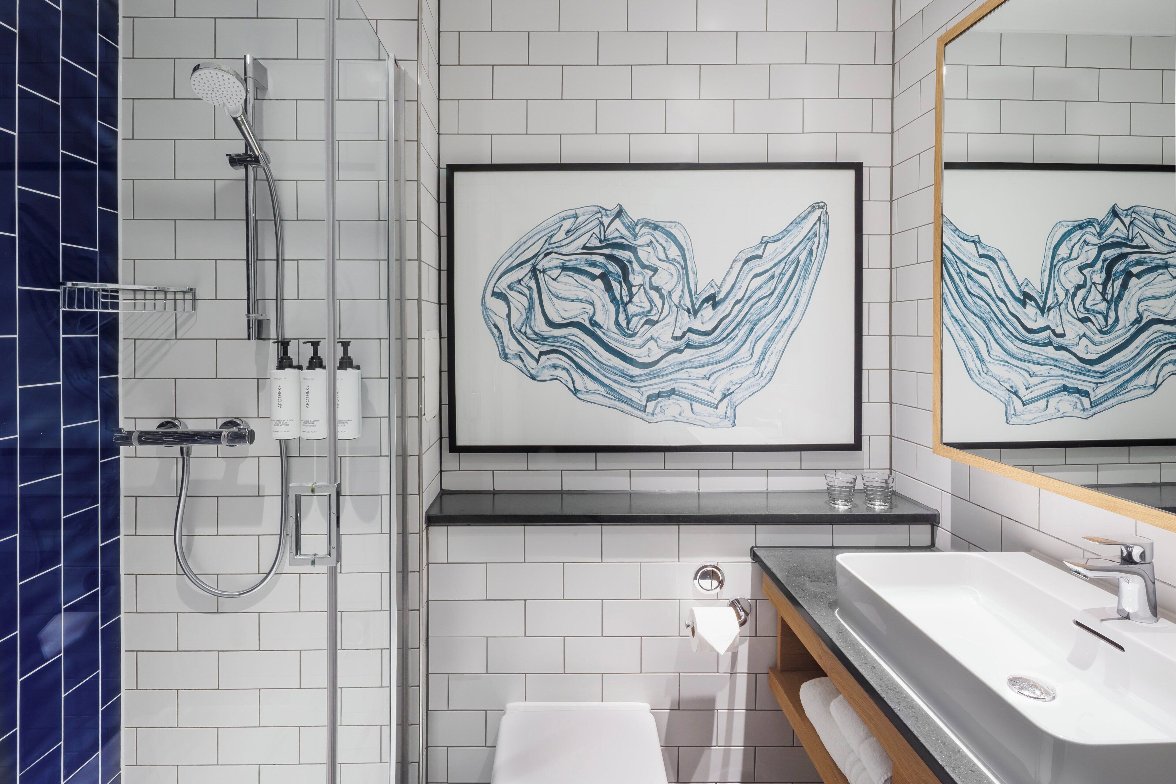 A modern bathroom with a shower, sink, and a large mirror.