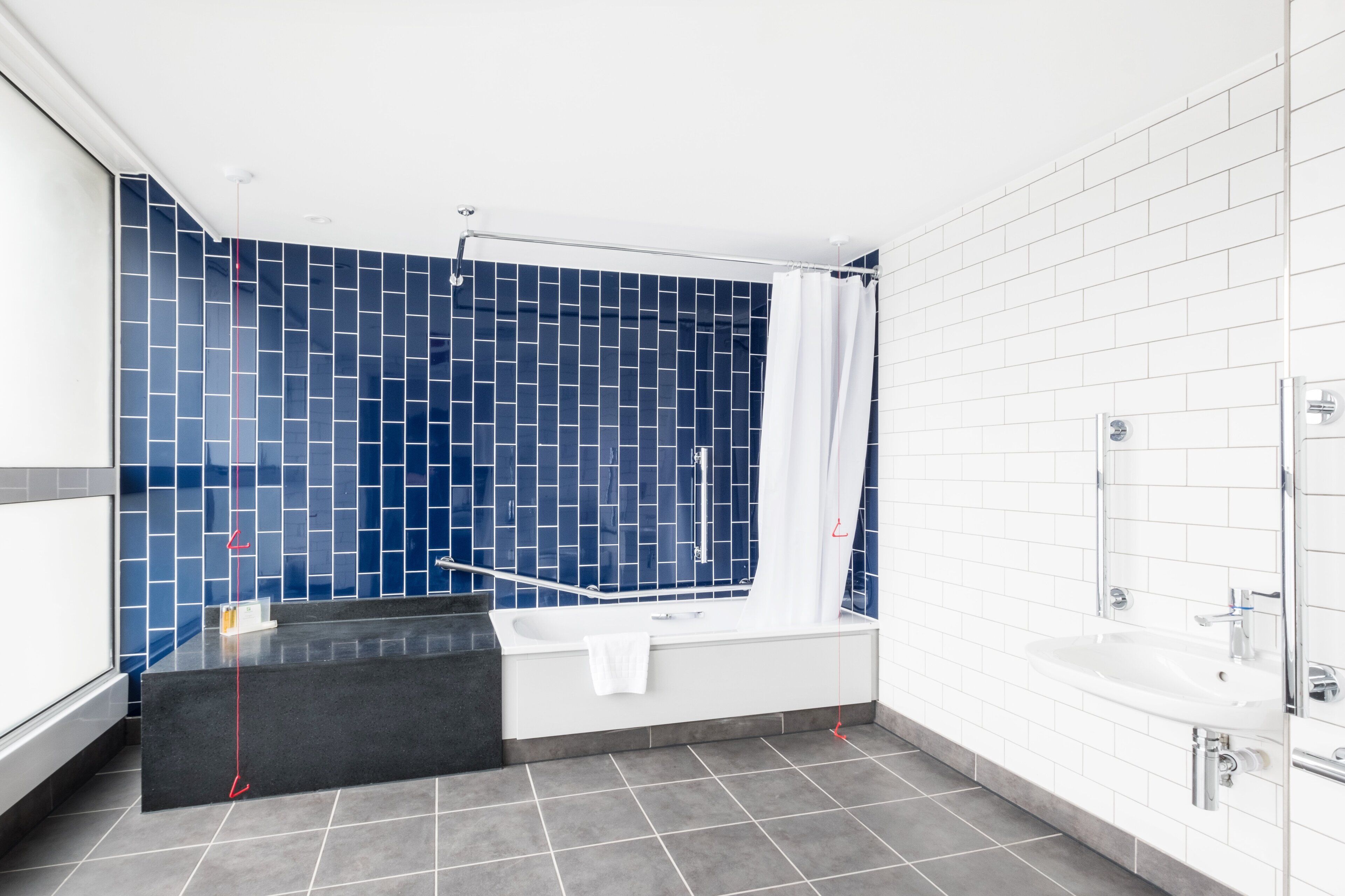 A modern bathroom with a bathtub, a shower area, and a sink.