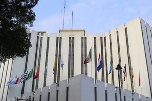 A modern building with multiple flags on its facade.