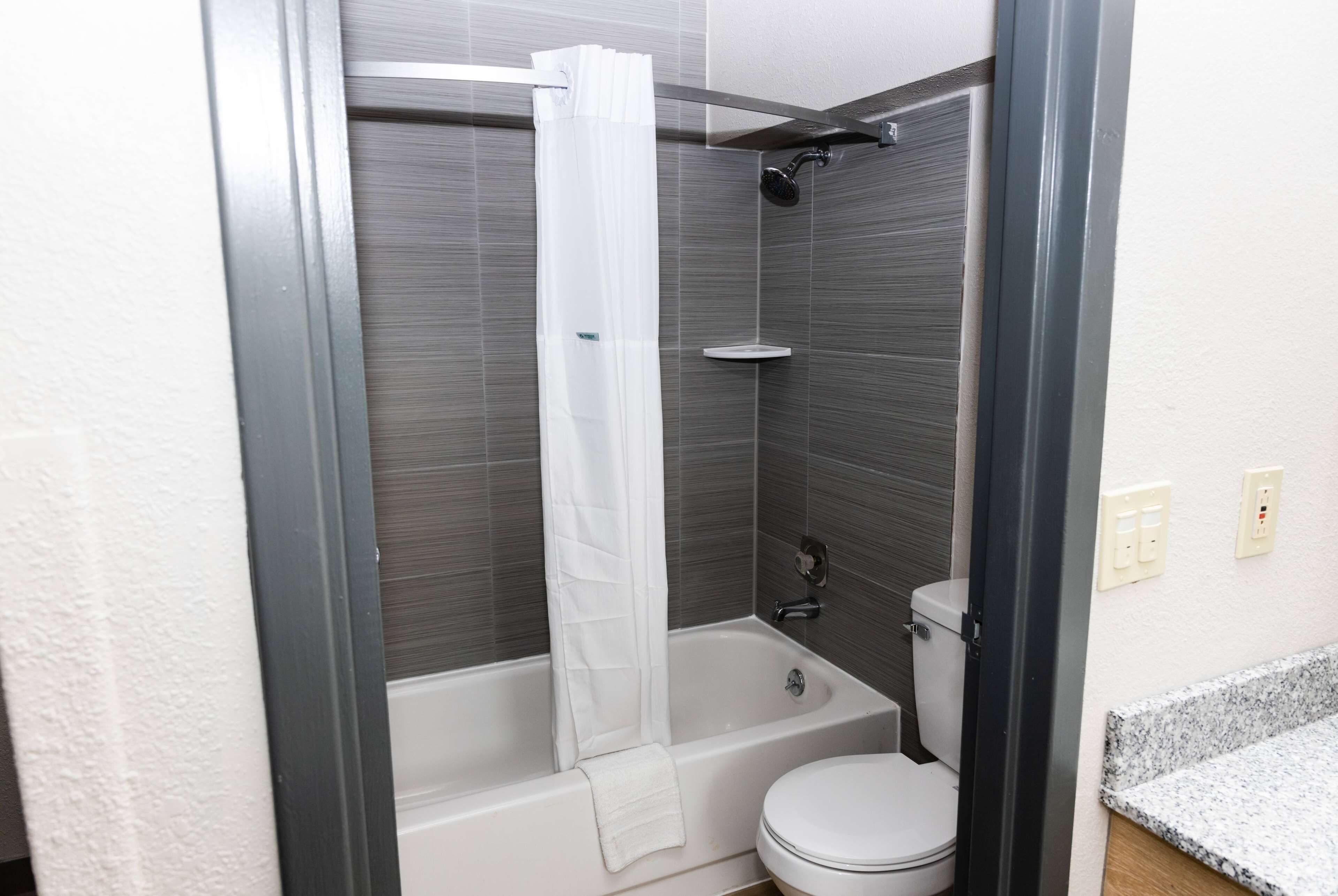 A bathroom with a bathtub, toilet, and shower curtain.