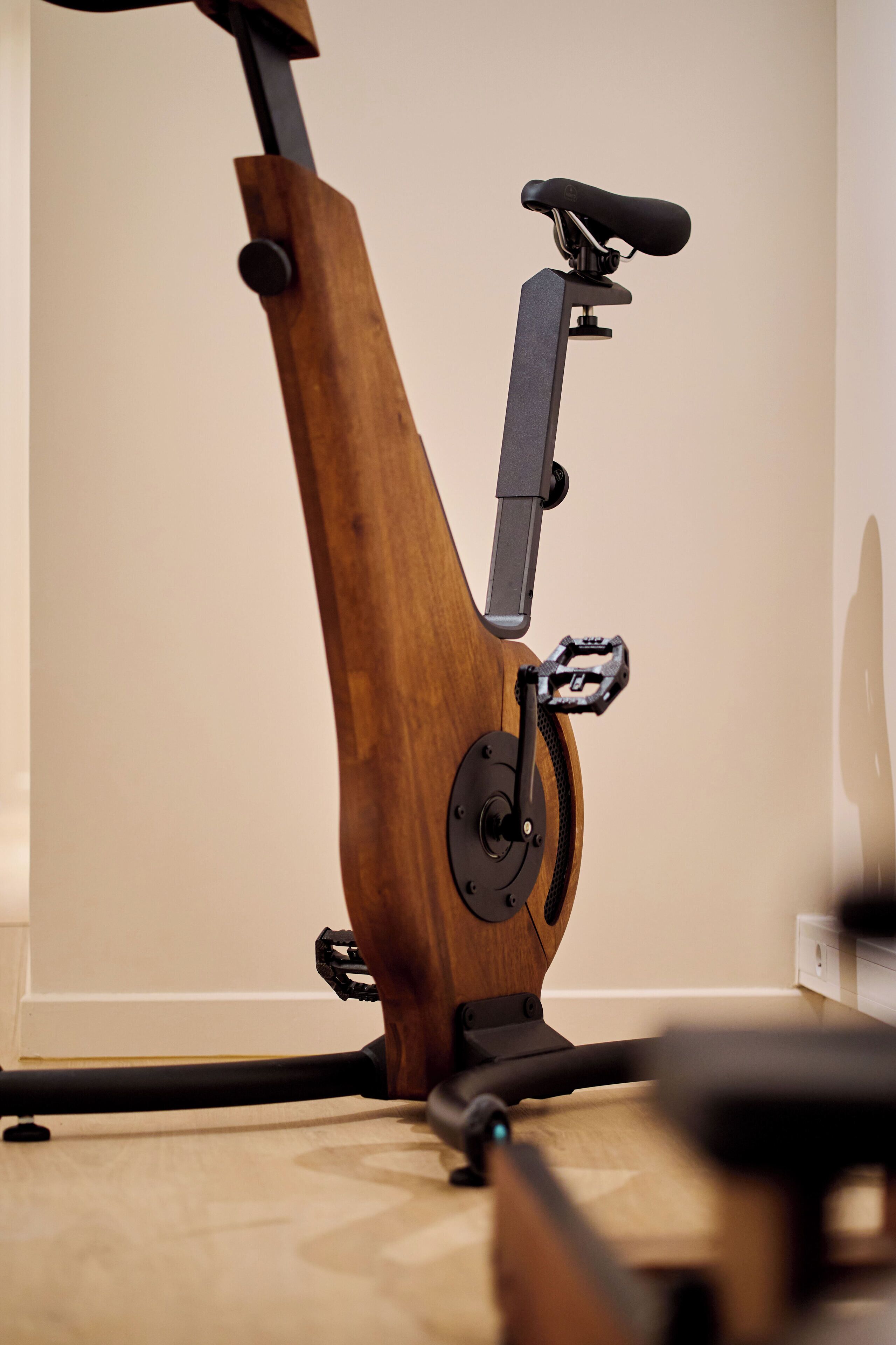 A stationary exercise bike with a wooden frame and black components.