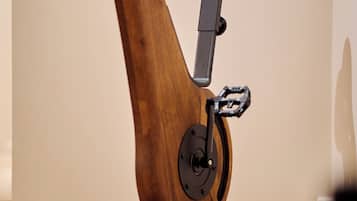 A stationary exercise bike with a wooden frame and black components.