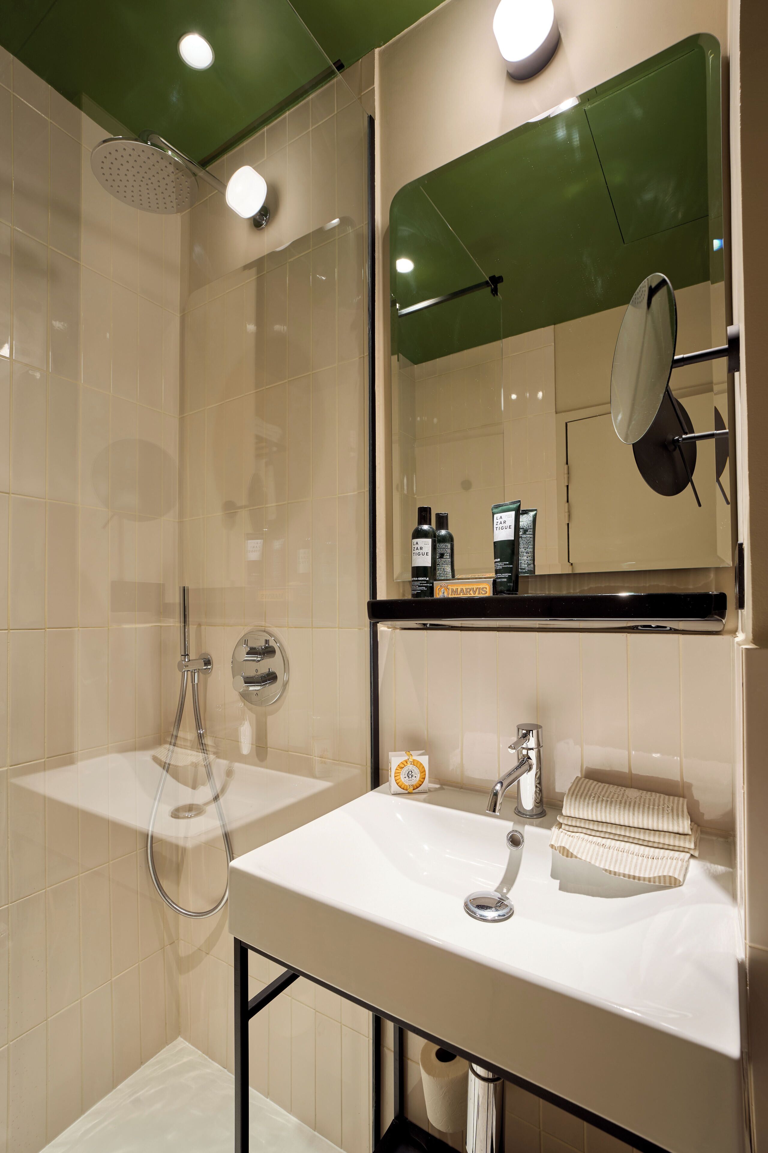 A modern bathroom with a shower, sink, and mirror.