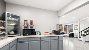 Una cocina moderna con gabinetes grises, microondas, tostadora y cafetera.