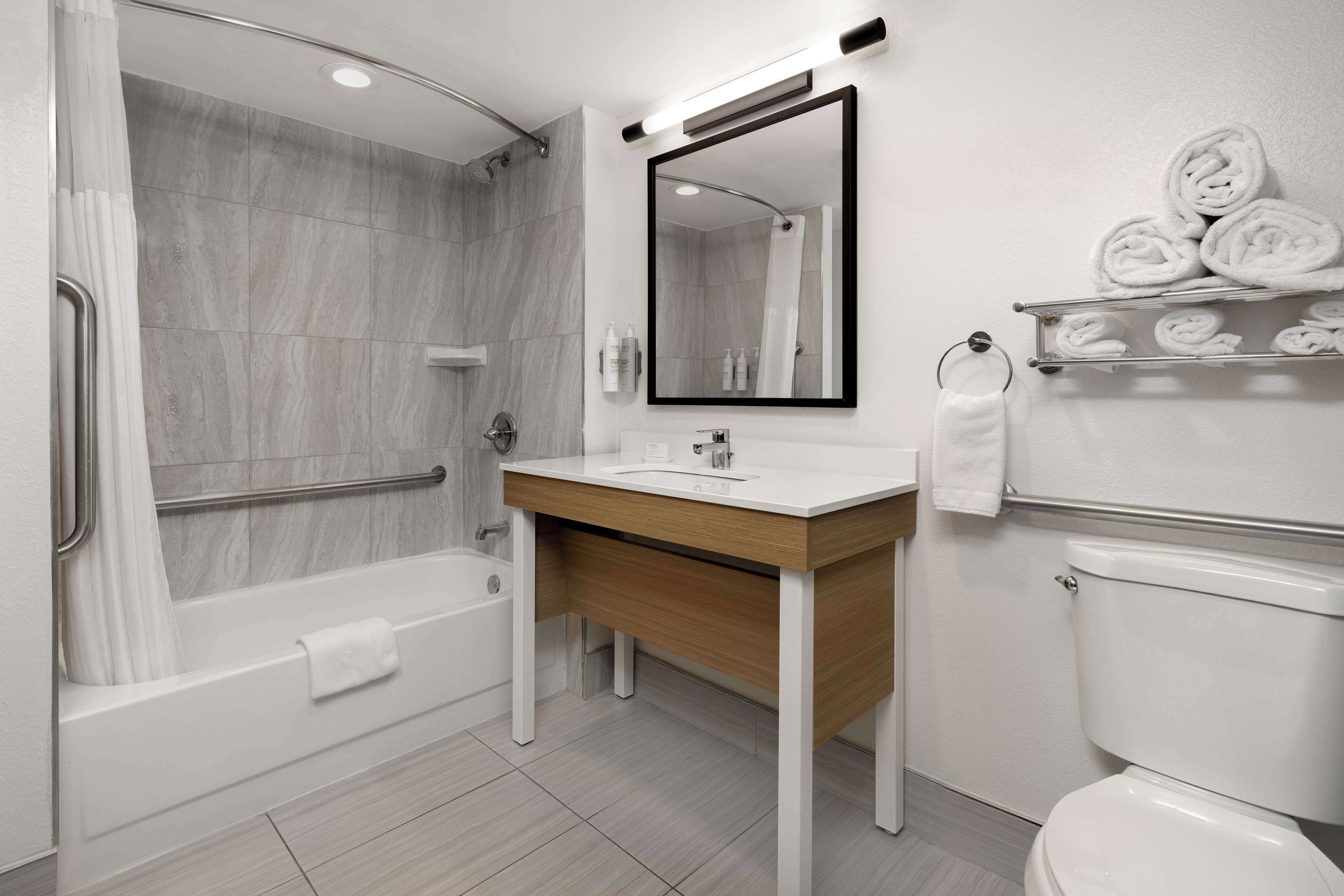 A modern bathroom with a bathtub, a sink, a toilet, and a shower.