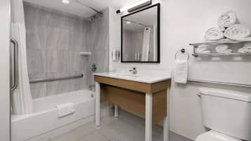 A modern bathroom with a bathtub, a sink, a toilet, and a shower.