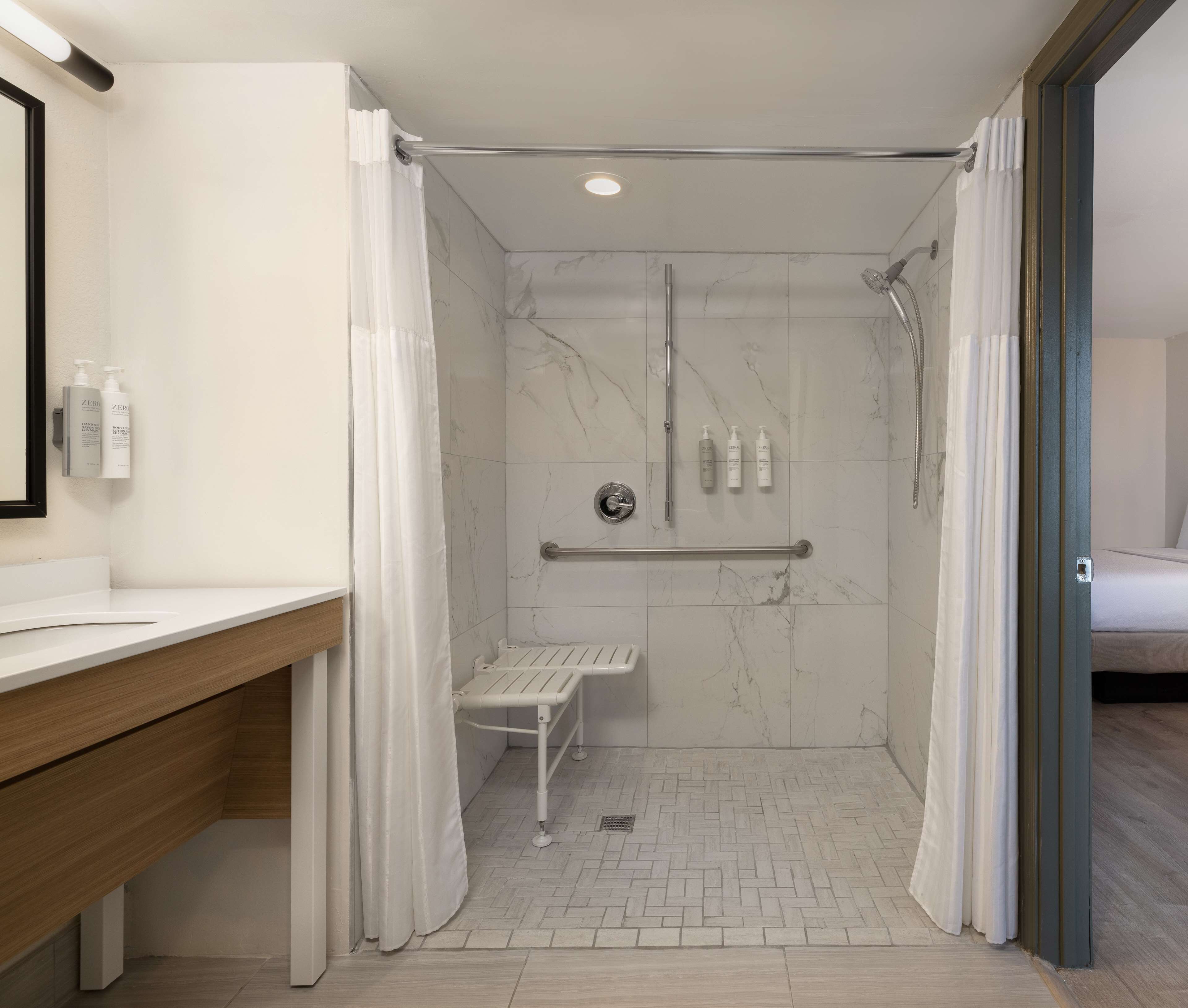 Ein modernes Badezimmer mit Dusche, Waschtisch mit Spiegel und Toilette.