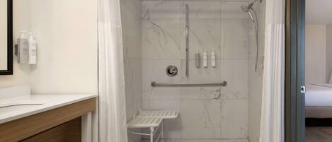 Ein modernes Badezimmer mit Dusche, Waschtisch mit Spiegel und Toilette.