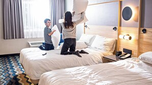 A hotel room with two beds, a bedside table with a phone, and a window with curtains. - Accent Inns Vancouver Airport (Richmond)