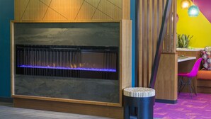 A modern room with a built-in fireplace, a wooden accent wall, and a vibrant color scheme. - Accent Inns Vancouver Airport (Richmond)
