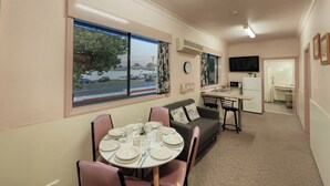 Un espacio habitable compacto con comedor, kitchenette y sofá.