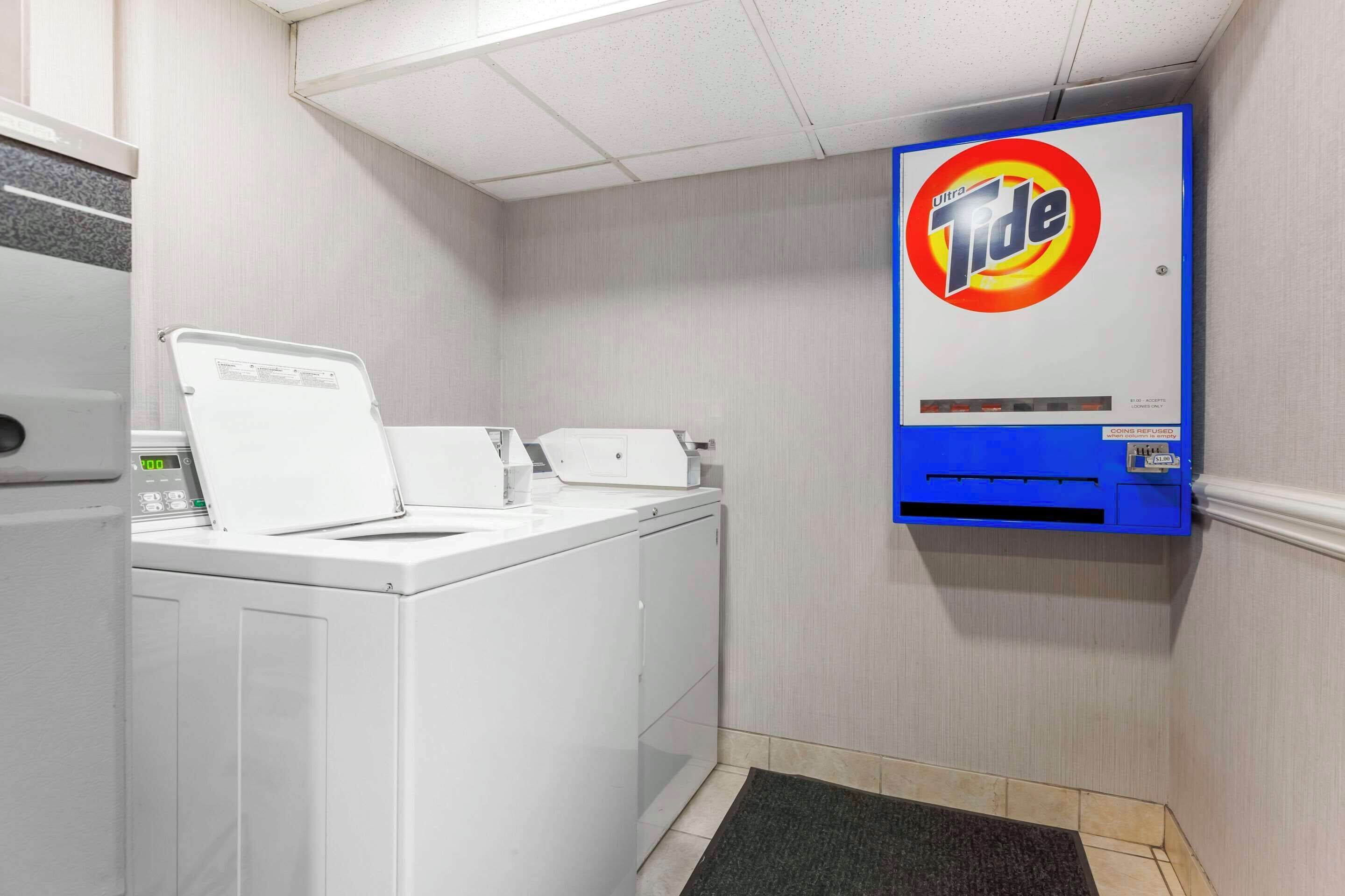 Une buanderie équipée d’un lave-linge, d’un sèche-linge et d’une machine à laver fixée au mur.
