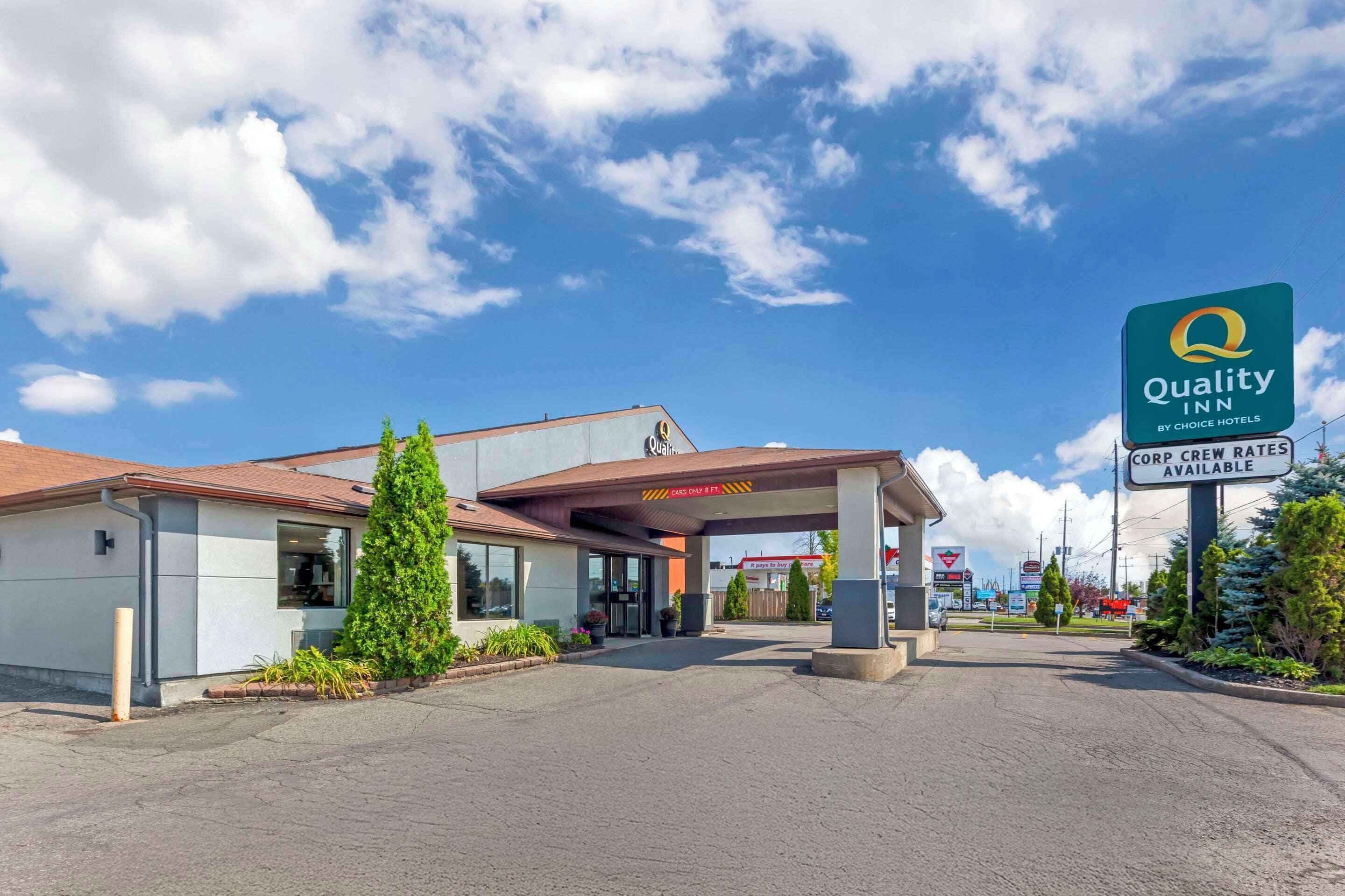 Un Quality Inn de Choice Hotels con cielo despejado, estacionamiento y un letrero que indica tarifas especiales para personal corporativo.