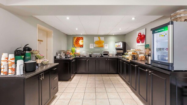 A modern kitchen with a central island, equipped with various appliances and a refrigerator.