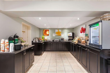 A modern kitchen with a central island, equipped with various appliances and a refrigerator.