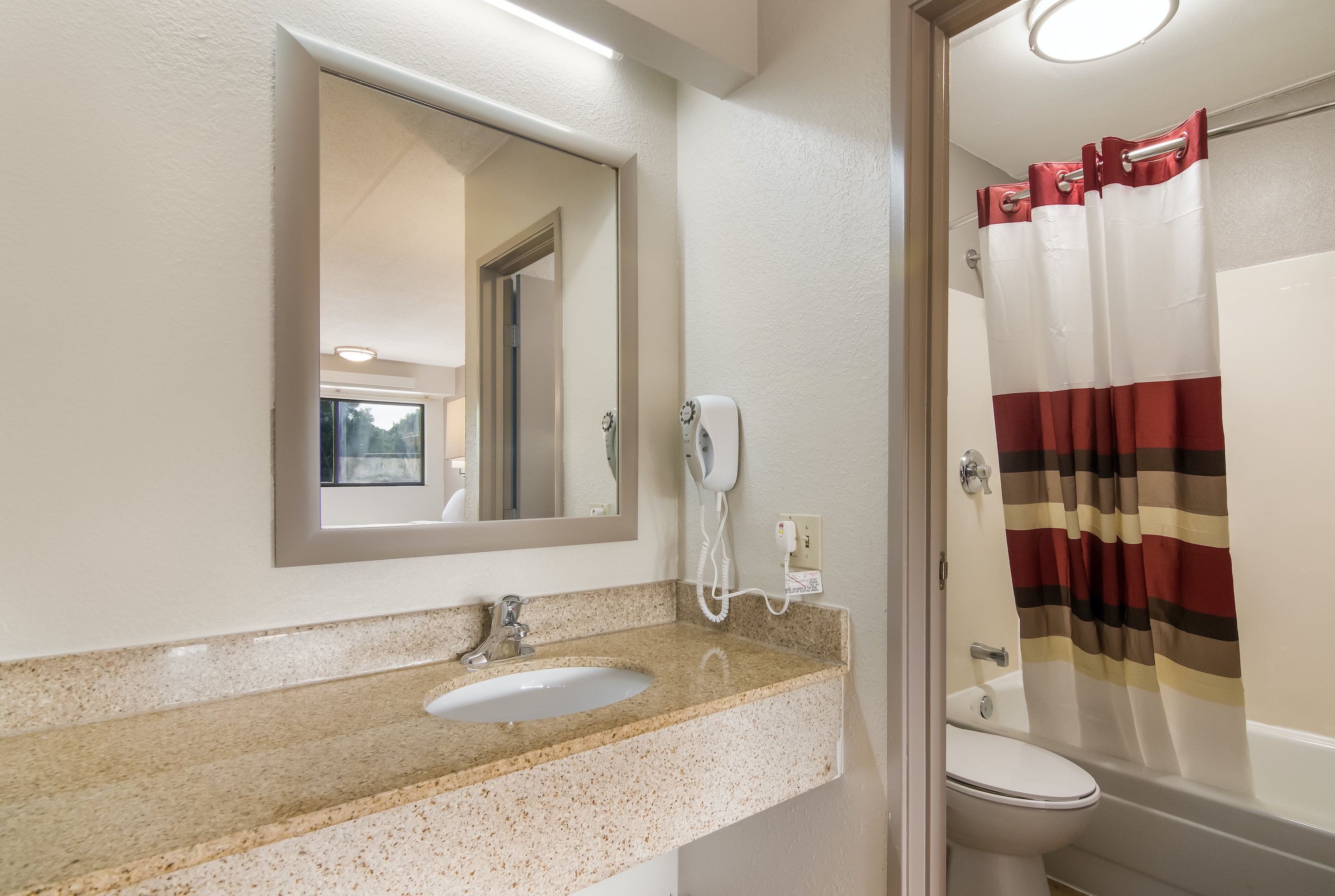 A bathroom with a sink, mirror, and toilet.