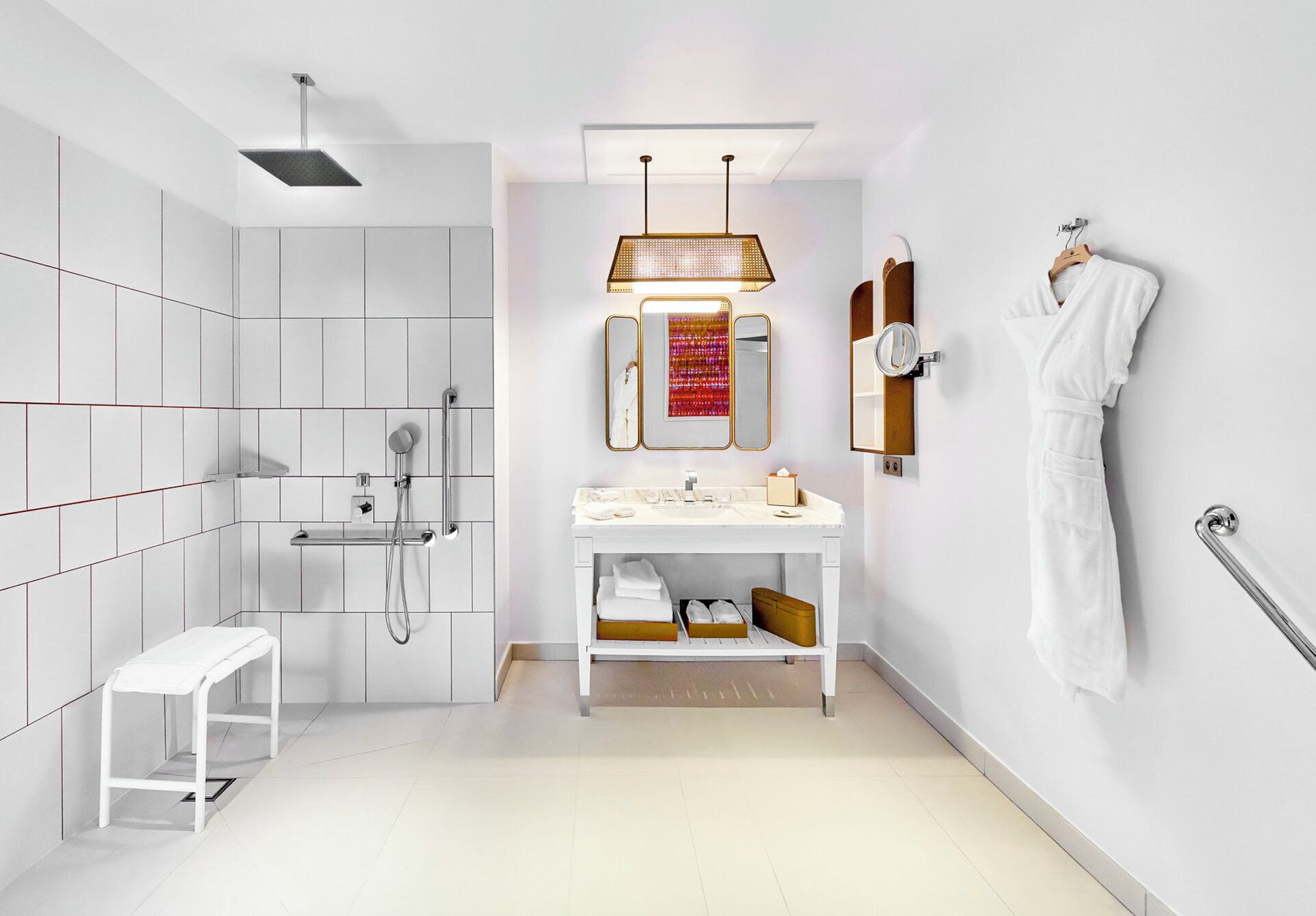 A modern bathroom with a shower, toilet, and sink. There is a bench, a towel rack, and a mirror.