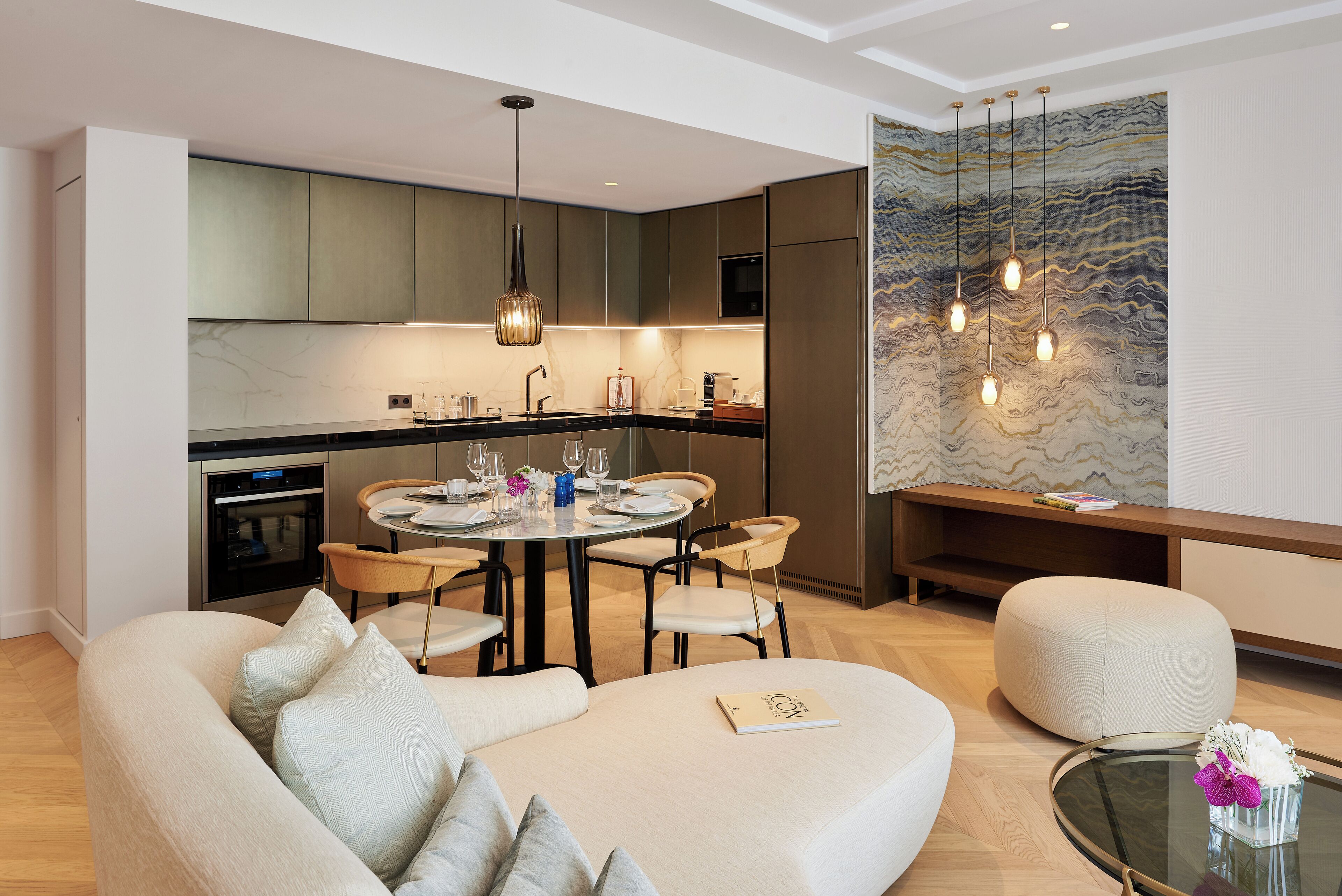 A modern kitchen with a dining area, a sofa, and a coffee table.
