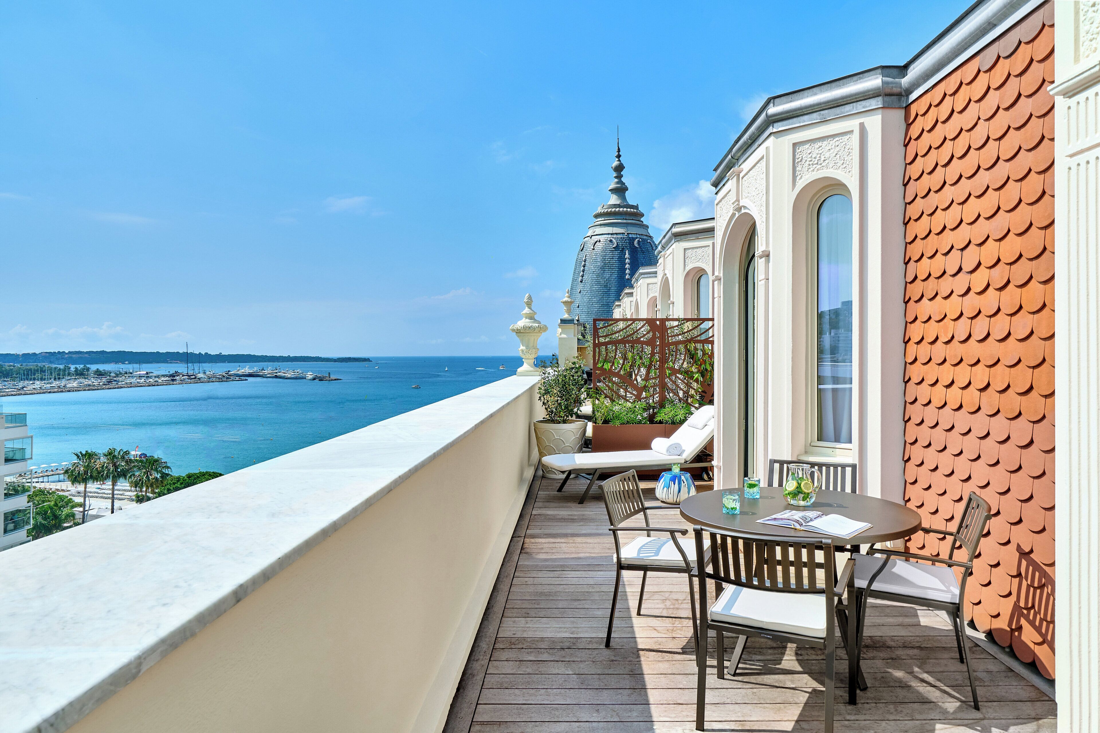 A balcony with a view of the sea and a temple-like structure.