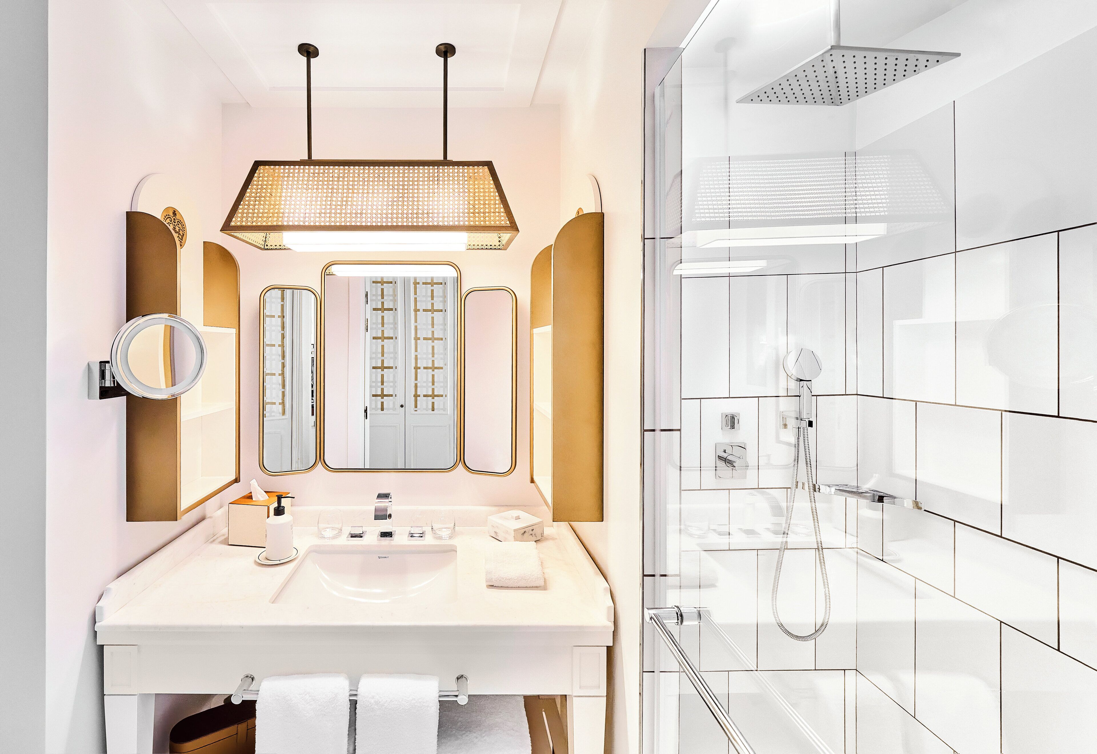A modern bathroom with a white vanity, a large mirror, and a shower area.
