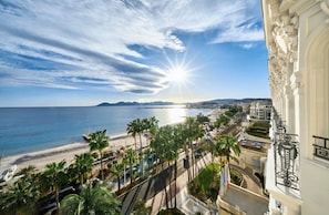 Un paysage urbain côtier avec une plage, des palmiers et un ciel dégagé.