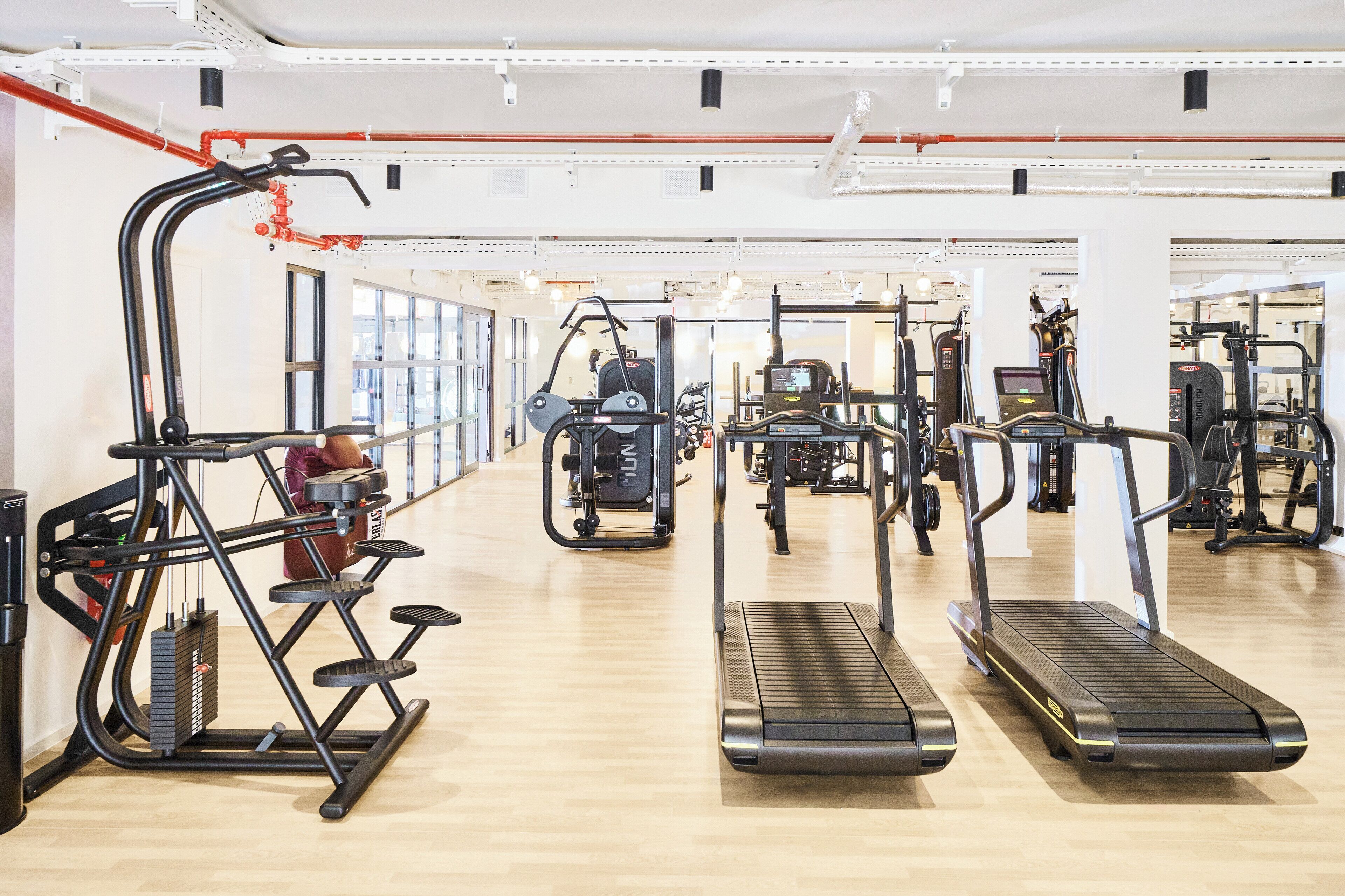 A gym with treadmills, elliptical machines, and weightlifting equipment.