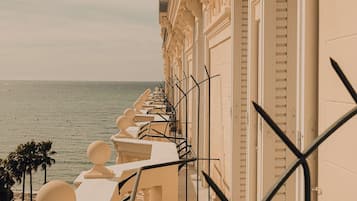 Un balcón con vistas al mar, que cuenta con una fila de barandas y un cielo despejado.