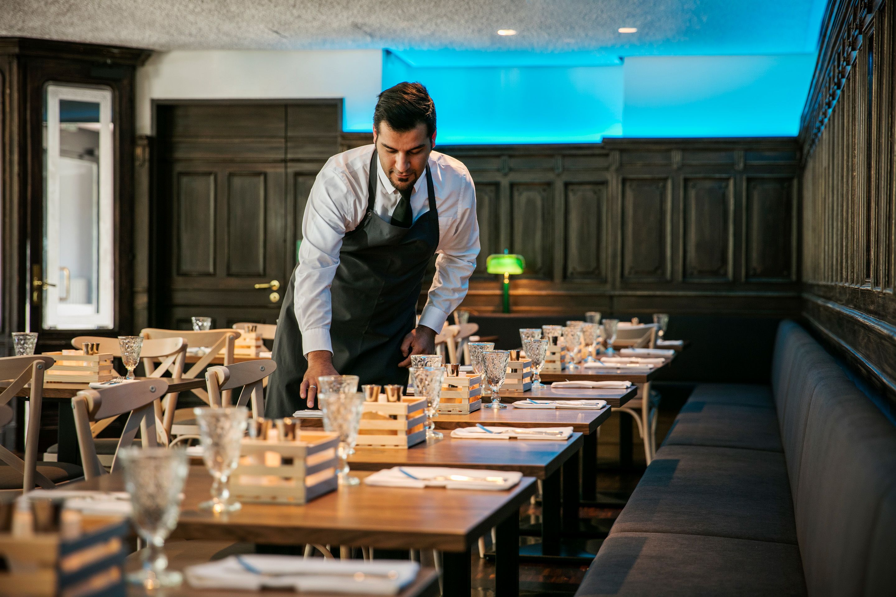 Un restaurante con mesas, sillas y un largo banco.