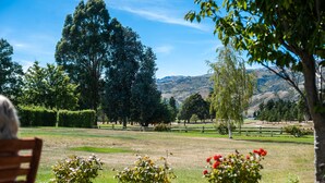 A park with a bench, trees, and a distant mountain range.