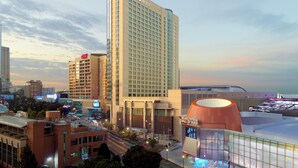 A hotel with a large sign, a modern building with a dome, and a stadium in the background. - Omni Atlanta Hotel at Centennial Park (Atlanta)