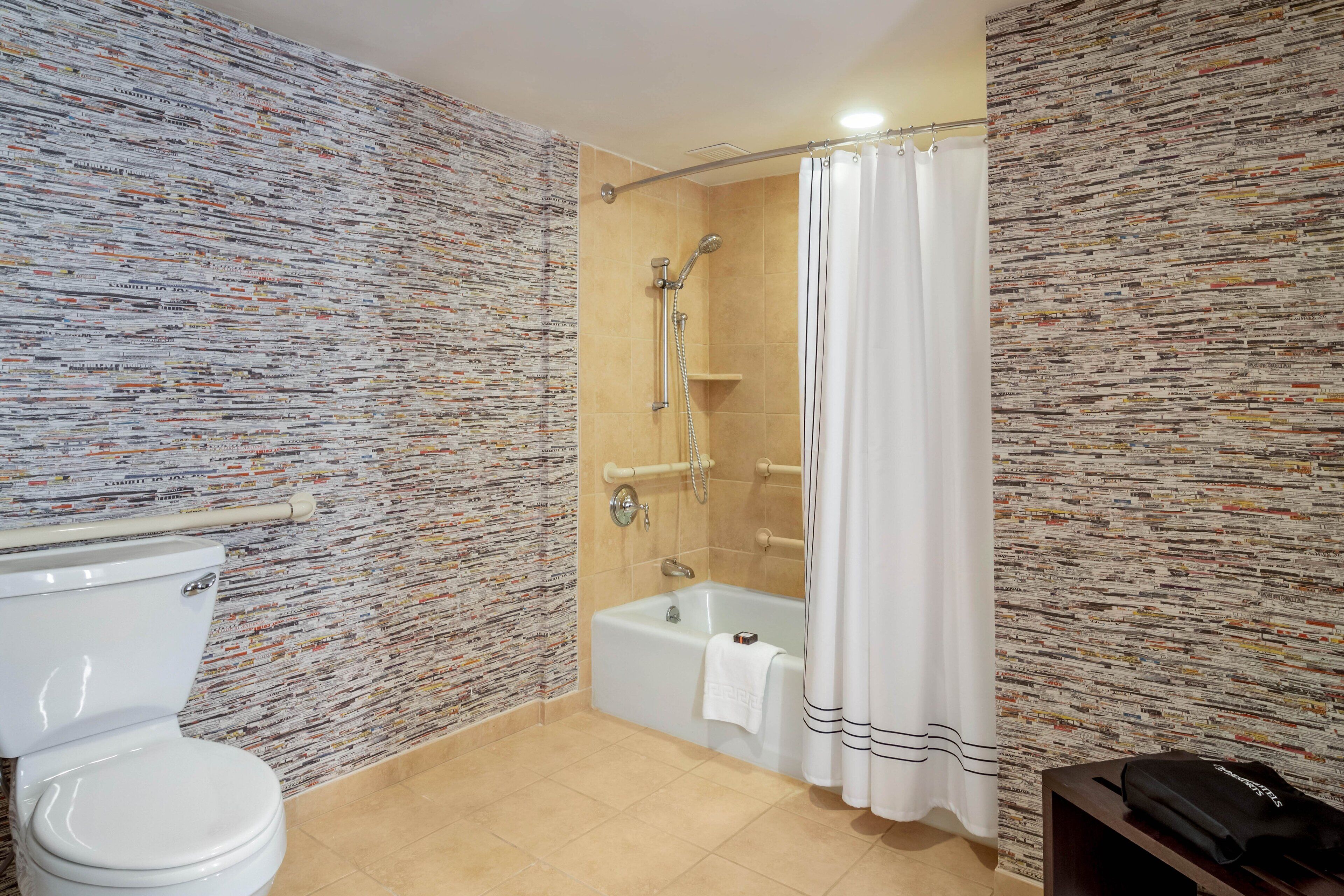 Une salle de bain avec douche, toilettes et baignoire.