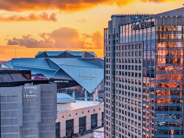 Um hotel com design moderno, o estádio Mercedes-Benz, e um edifício alto com fachada de vidro.